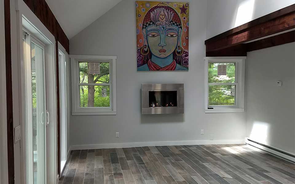 empty living room with indoor fireplace and mural 3